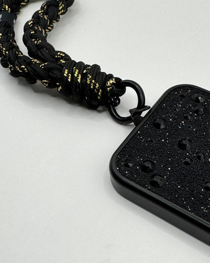Black and gold braided necklace with a black pendant on a light gray background